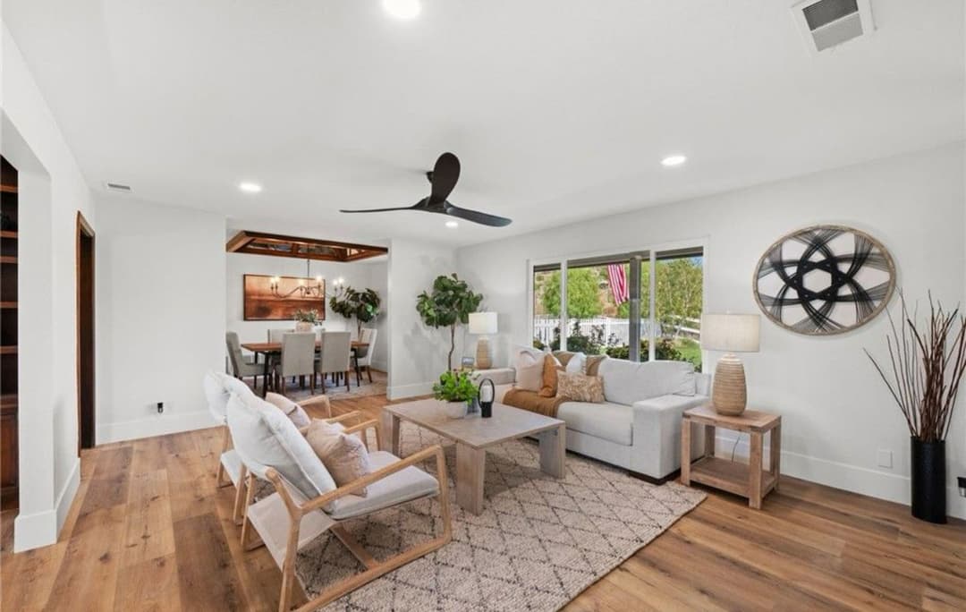 Modern living room with cozy furniture, plant accents, and large windows for natural light.