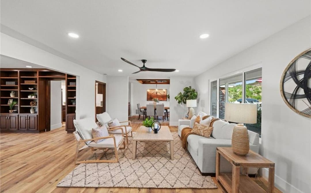 Modern living room with neutral decor, wooden accents, and natural light. Cozy and inviting space.