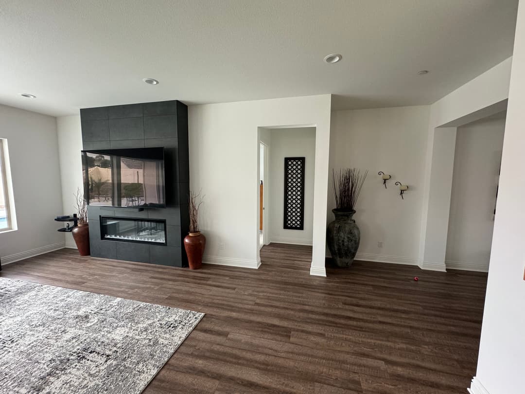 Modern living room with fireplace, decorative vases, and open floor plan. Stylish wooden flooring.
