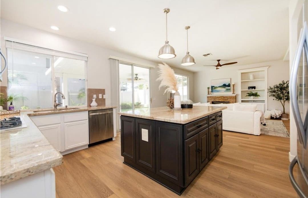 Modern kitchen with a central island, stainless steel appliances, and natural lighting.