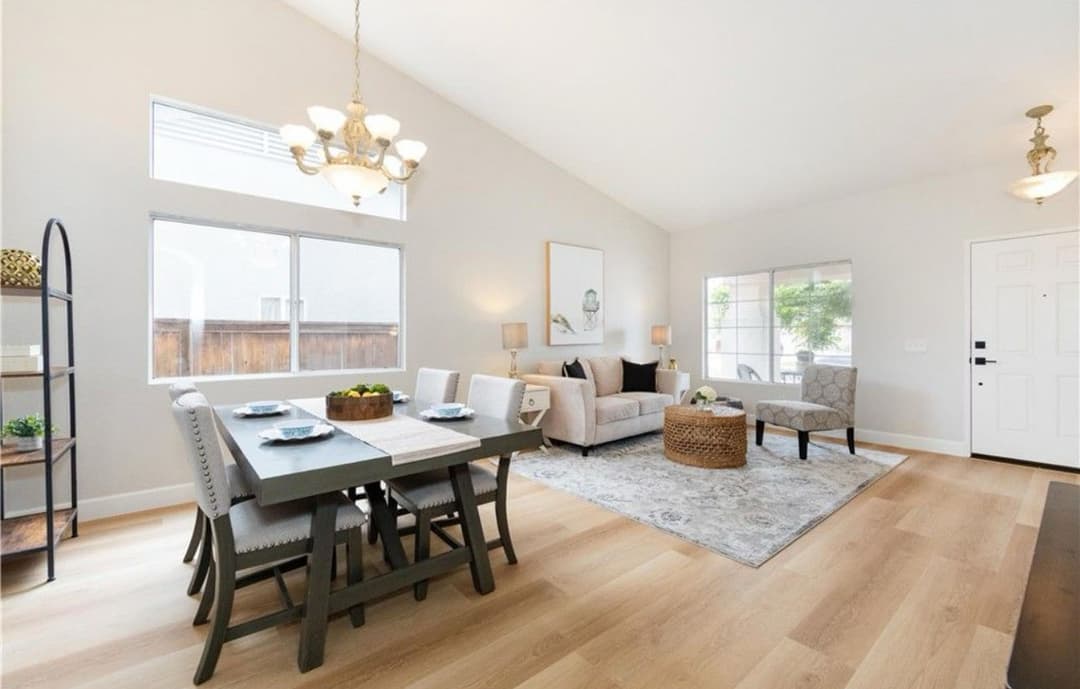 Modern living room and dining area with natural light, stylish furniture, and a cozy atmosphere.