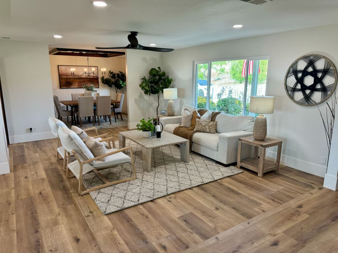 Modern living room with neutral decor, cozy furniture, and wooden flooring. Bright and inviting space.