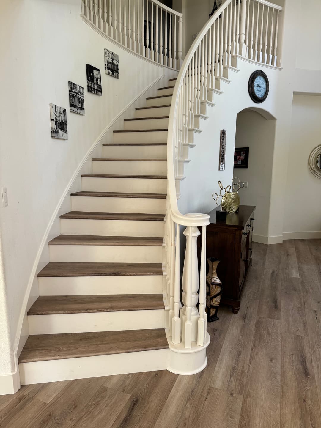 Spiral staircase with wooden steps, white bannister, and minimalistic decor in a modern home.