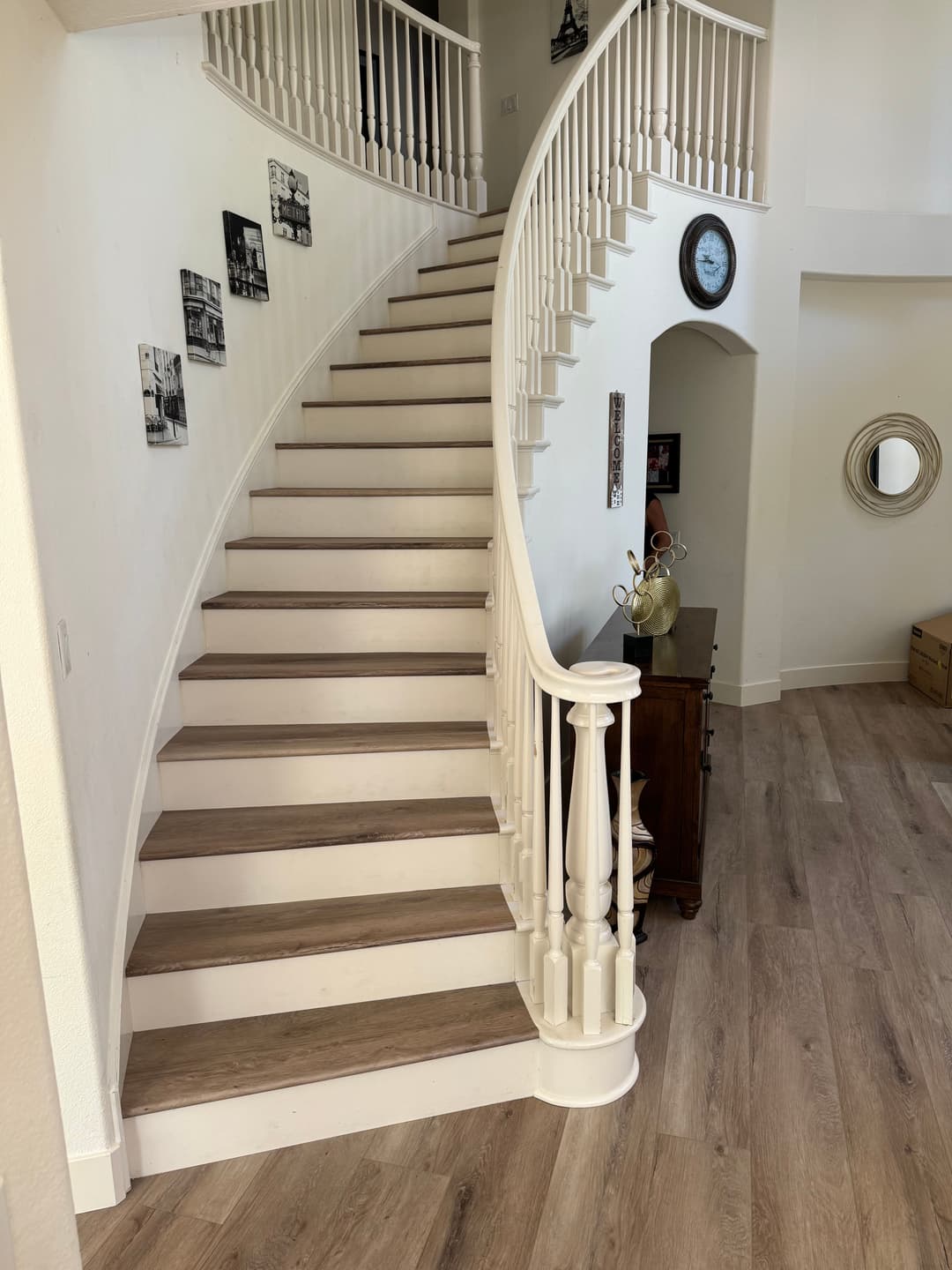 Elegant curved staircase with wooden steps, surrounded by bright walls and decorative accents.