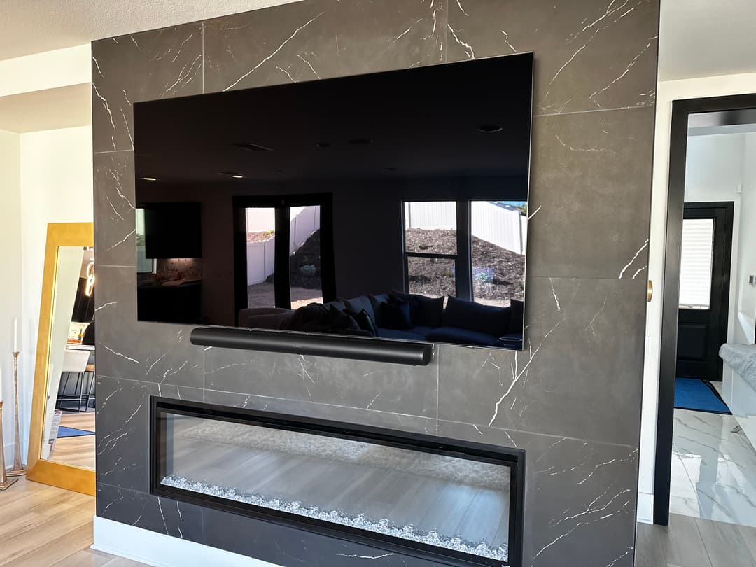 Modern living room featuring a wall-mounted TV above a stylish electric fireplace.