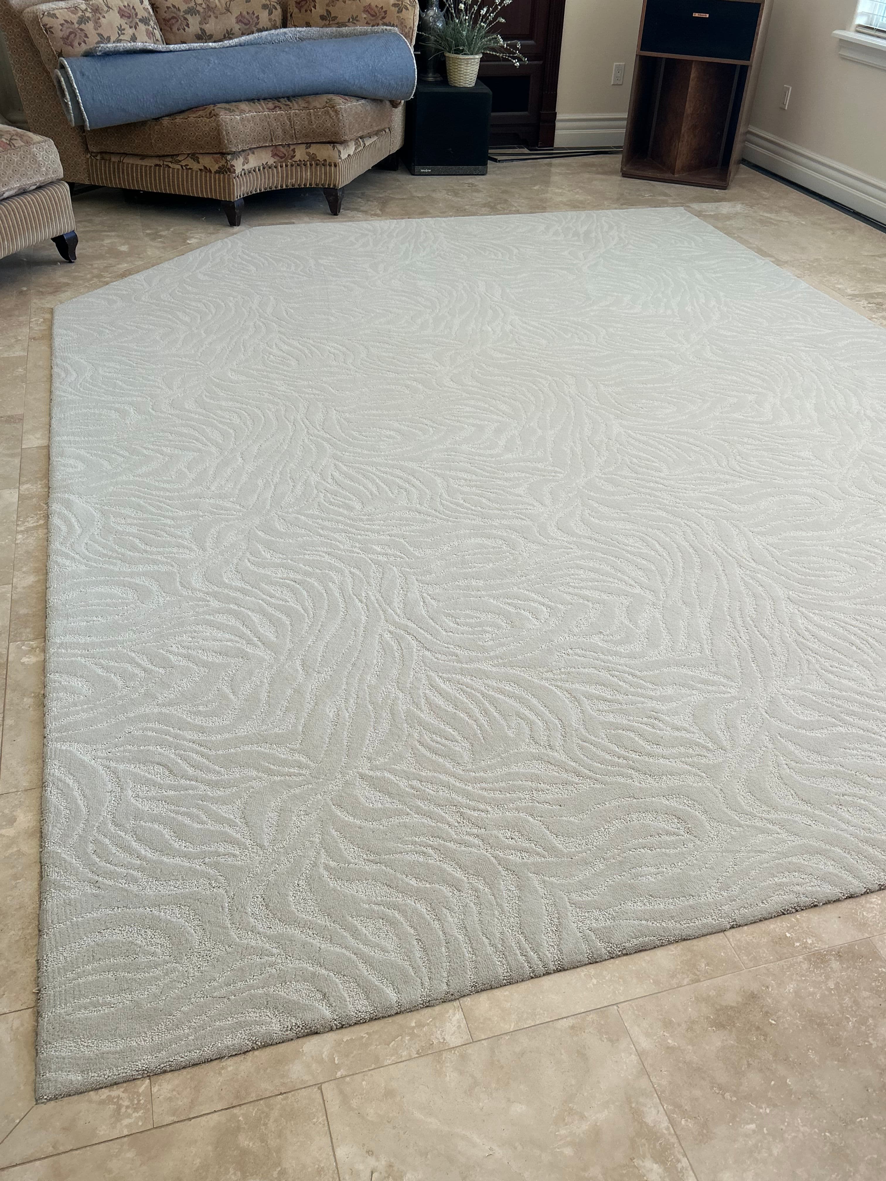 Light textured area rug on tiled floor in a cozy living room setting.