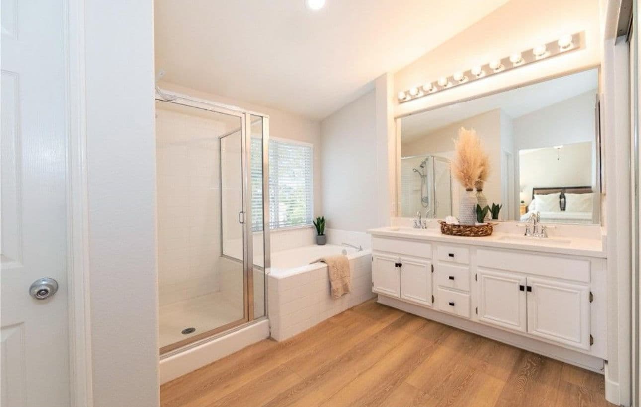 Modern bathroom with shower, soaking tub, double vanity, and natural decor elements.
