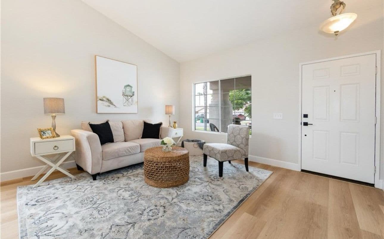 Bright living room with neutral decor, comfortable sofa, and stylish accent chair.